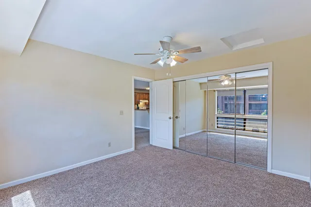 en empty room with a ceiling fan and a window