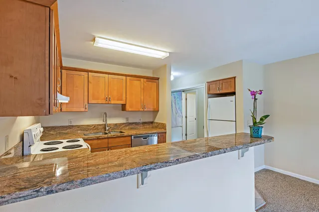 a kitchen with granite countertop a sink and a stove
