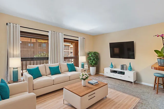 a living room with furniture a flat screen tv and a large window