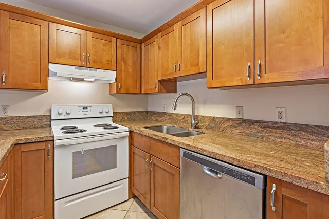 a kitchen with stainless steel appliances granite countertop a sink a stove and cabinets