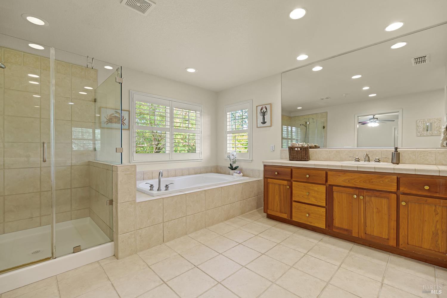 68 Pinheiro Circle Novato, CA 94945 - Photo 44 of 82 Spa-Inspired Primary Bathroom: The luxurious primary bath features dual vanities, a dedicated makeup station, a soaking tub, separate walk-in shower, and generous storage—creating a functional and relaxing everyday retreat.