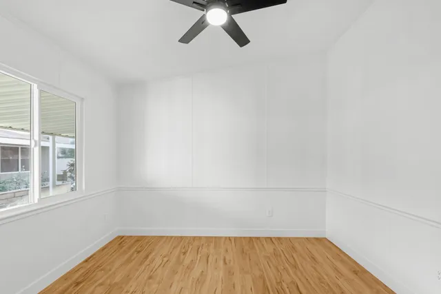 a view of a room with wooden floor and white walls