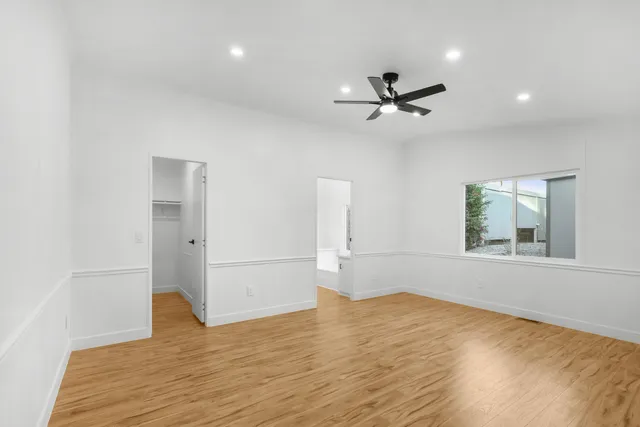 an empty space with wooden floor and windows