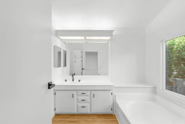 a bathroom with a sink mirror and a bathtub