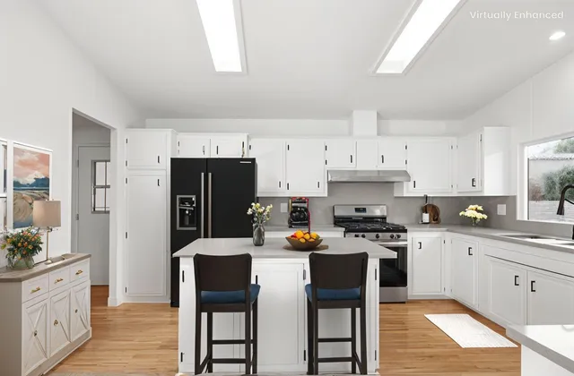 a kitchen with stainless steel appliances a stove a sink island and a refrigerator