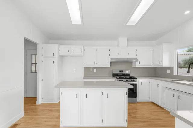 a kitchen with cabinets appliances and wooden floor