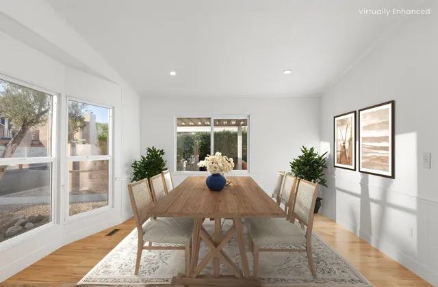 a view of a dining room with furniture wooden floor and a potted plant
