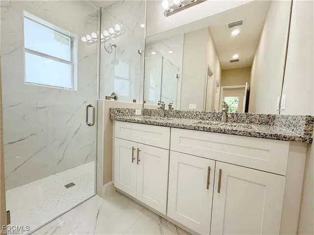 a bathroom with a shower sink and mirror