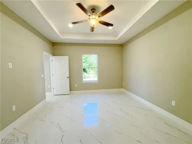 an empty room with windows and fan