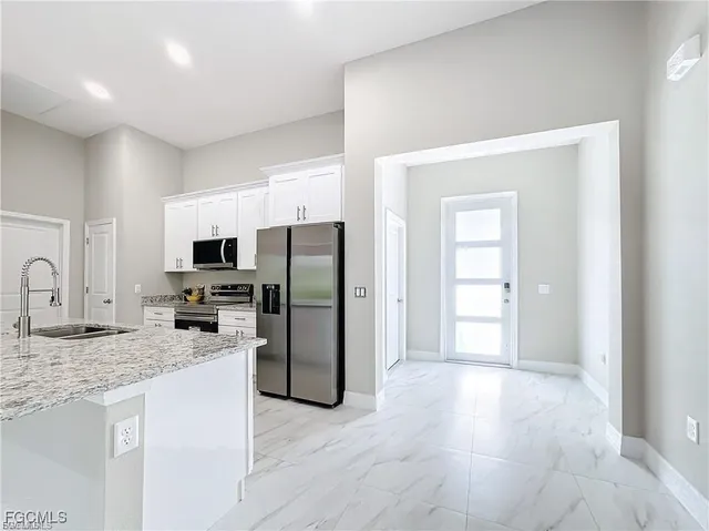 a kitchen with stainless steel appliances granite countertop a refrigerator a stove a sink and a granite counter tops