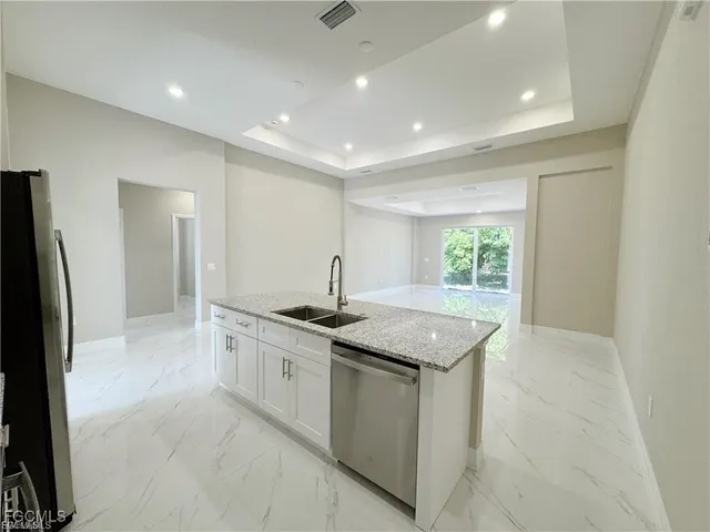 a kitchen with granite countertop sink and stainless steel appliances