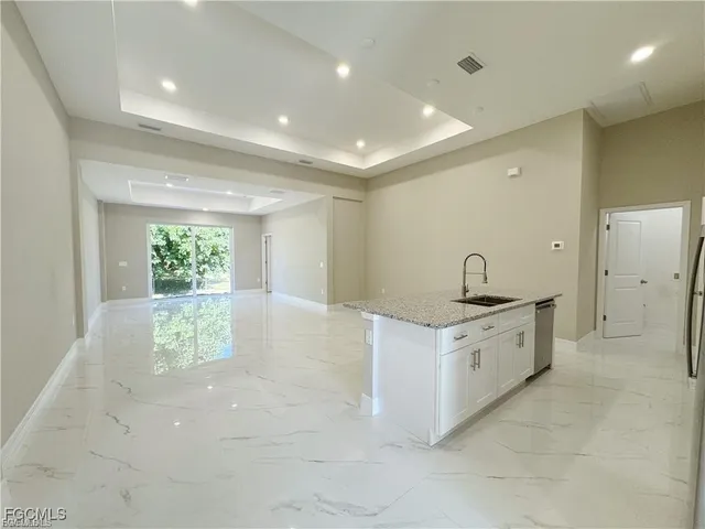 a large bathroom with a granite countertop sink a toilet a large mirror and shower