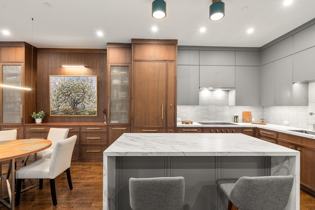 1471 Beacon Street, Unit 5 Brookline, MA 02446 - Photo 12 of 28 a kitchen with a table chairs sink and cabinets