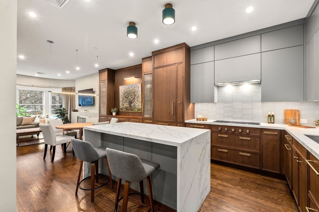 1471 Beacon Street, Unit 5 Brookline, MA 02446 - Photo 16 of 28 a large kitchen with cabinets a sink a island and chairs in it