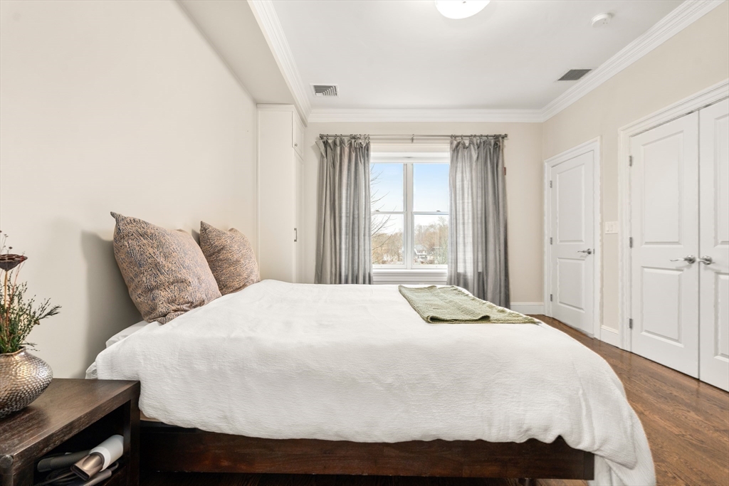 1471 Beacon Street, Unit 5 Brookline, MA 02446 - Photo 19 of 28 a bedroom with a bed and wooden floor