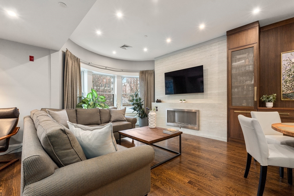 1471 Beacon Street, Unit 5 Brookline, MA 02446 - Photo 4 of 28 a living room with furniture a flat screen tv and a fireplace
