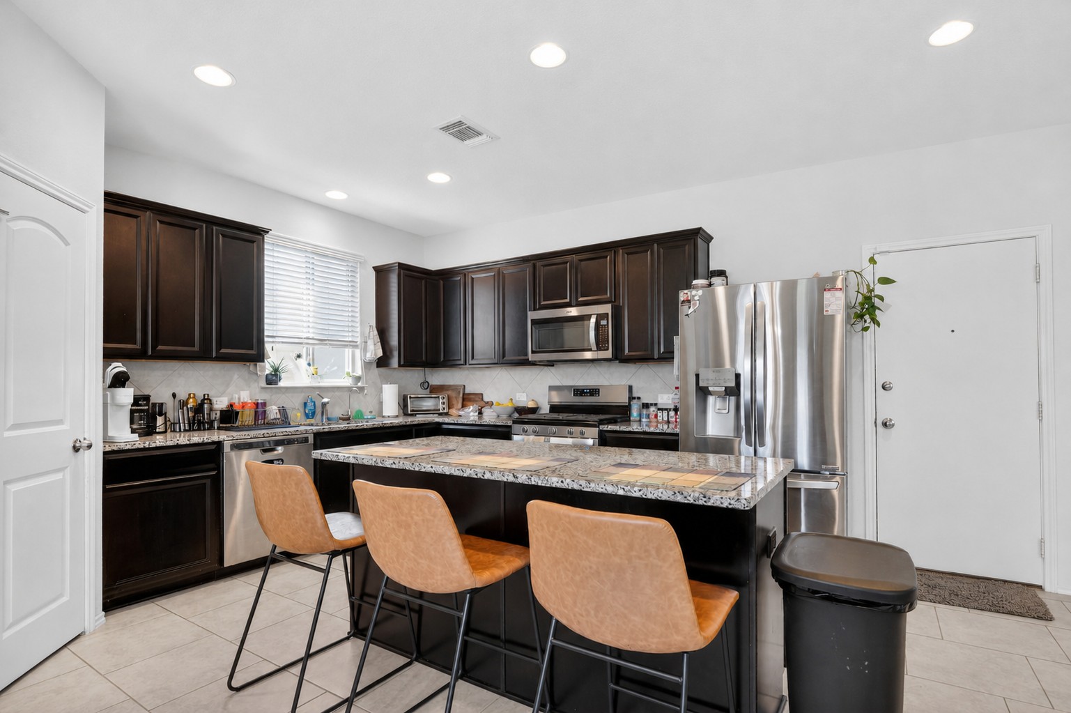 521 Staton Street Georgetown, TX 78626 - Photo 5 of 39 a kitchen with granite countertop a sink stove and refrigerator