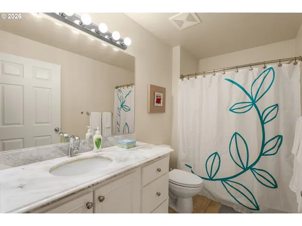 a bathroom with a granite countertop sink a mirror a vanity and a shower