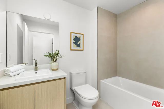 a bathroom with a granite countertop sink a toilet and shower