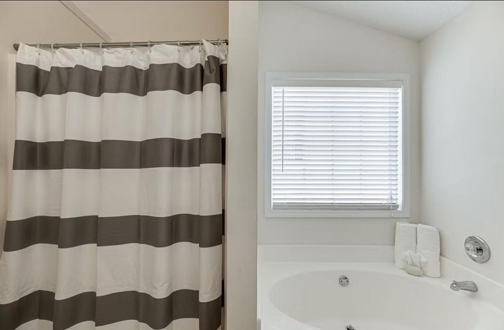 1281 Key Manor Lane Lawrenceville, GA 30045 - Photo 11 of 22 a bathroom with a bathtub and a shower curtain