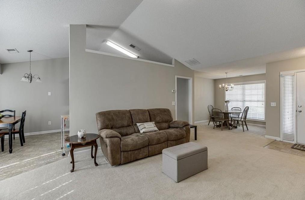 1281 Key Manor Lane Lawrenceville, GA 30045 - Photo 3 of 22 a living room with furniture and a dining table with kitchen view