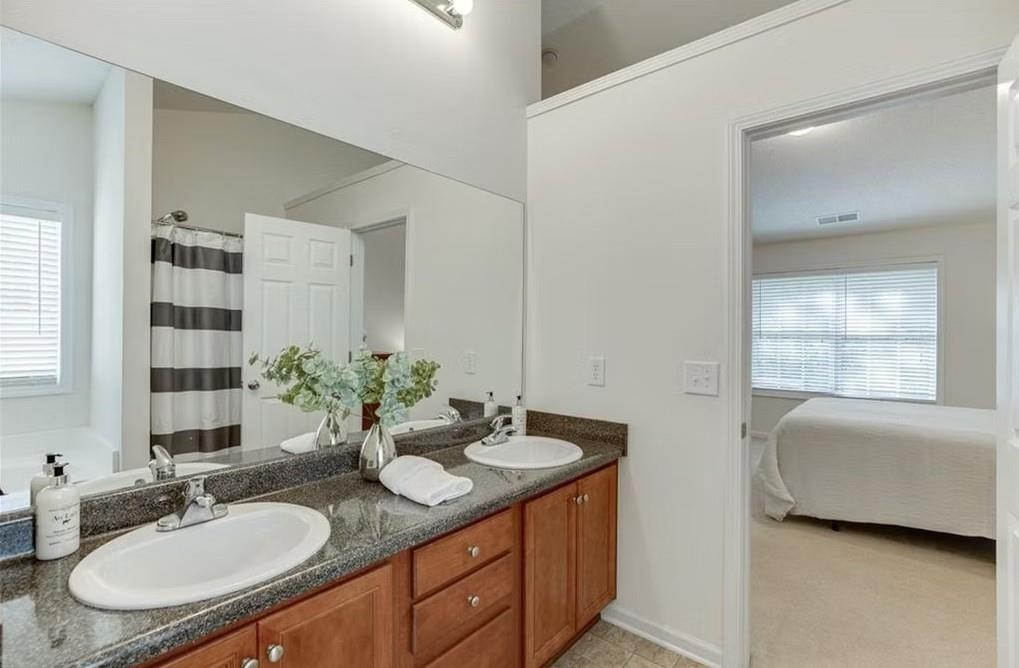 1281 Key Manor Lane Lawrenceville, GA 30045 - Photo 9 of 22 a bathroom with a granite countertop sink and a mirror