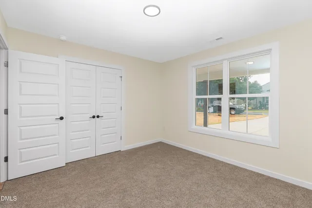 an empty room with windows and closet