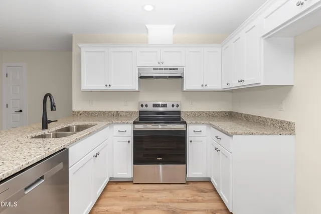 a kitchen with a stove sink and cabinets