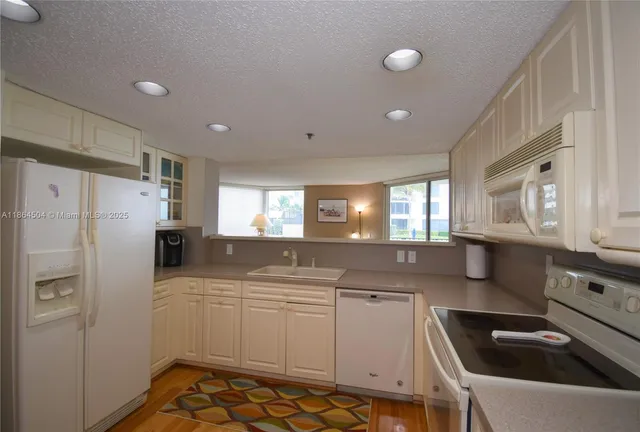 a kitchen that has a sink cabinets counter space and appliances