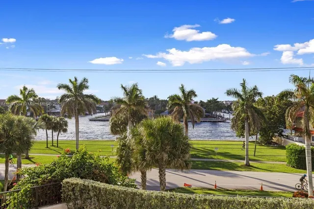 a view of a hallway with wooden floor and living room