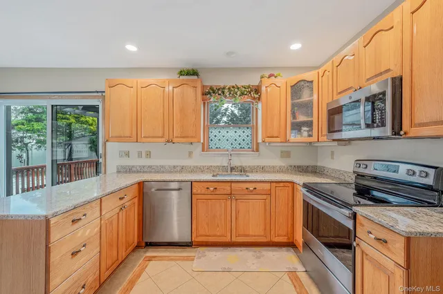 a kitchen with stainless steel appliances granite countertop a stove sink and cabinets