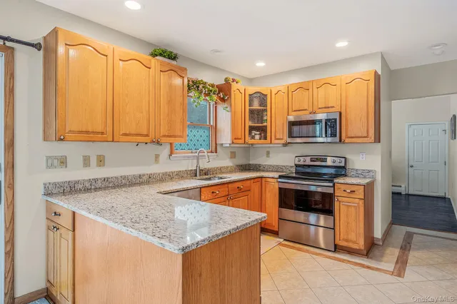 a kitchen with stainless steel appliances granite countertop a stove a sink and a microwave