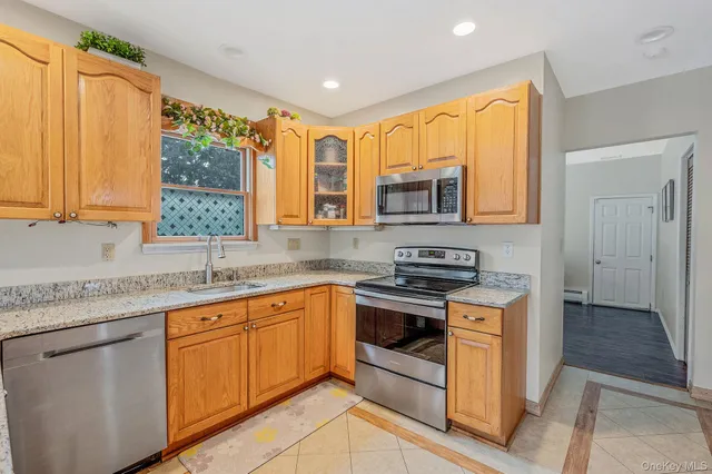 a kitchen with stainless steel appliances granite countertop wooden cabinets a sink and a stove