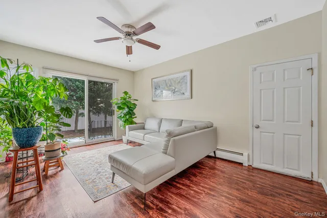 a living room with furniture and a large window with wooden floor