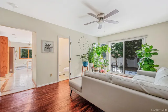a living room with furniture and a large window with wooden floor