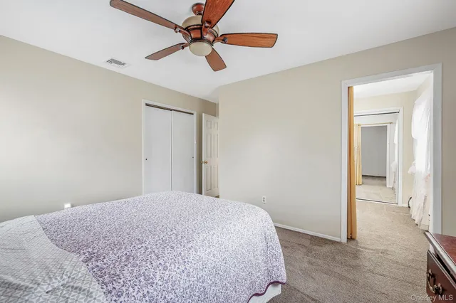 a bedroom with a bed and a chandelier fan