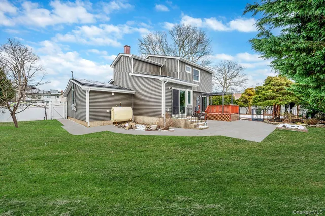 a front view of a house with garden and trees