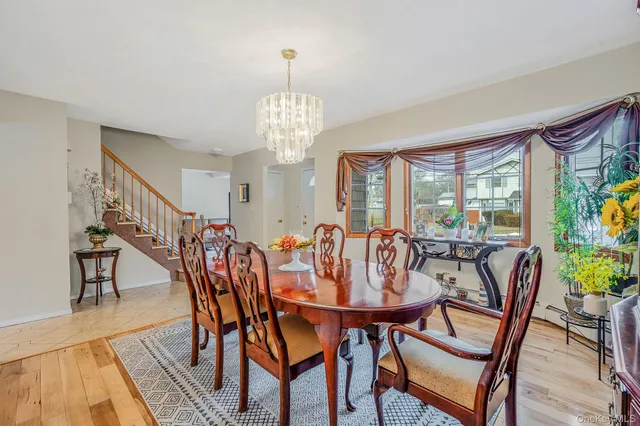 a view of a dining room with furniture a chandelier and wooden floor