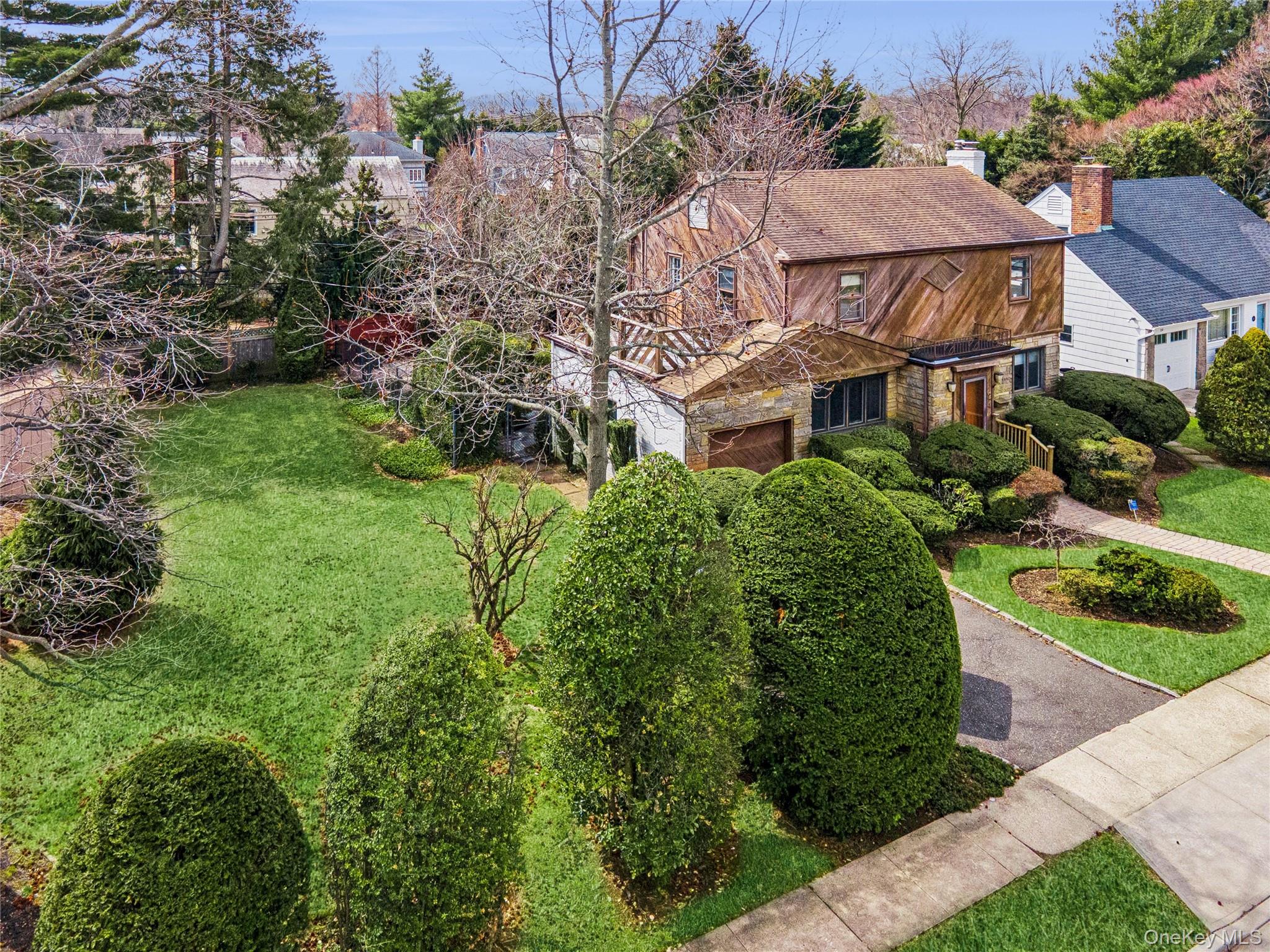 a view of a white house next to a yard with potted plants