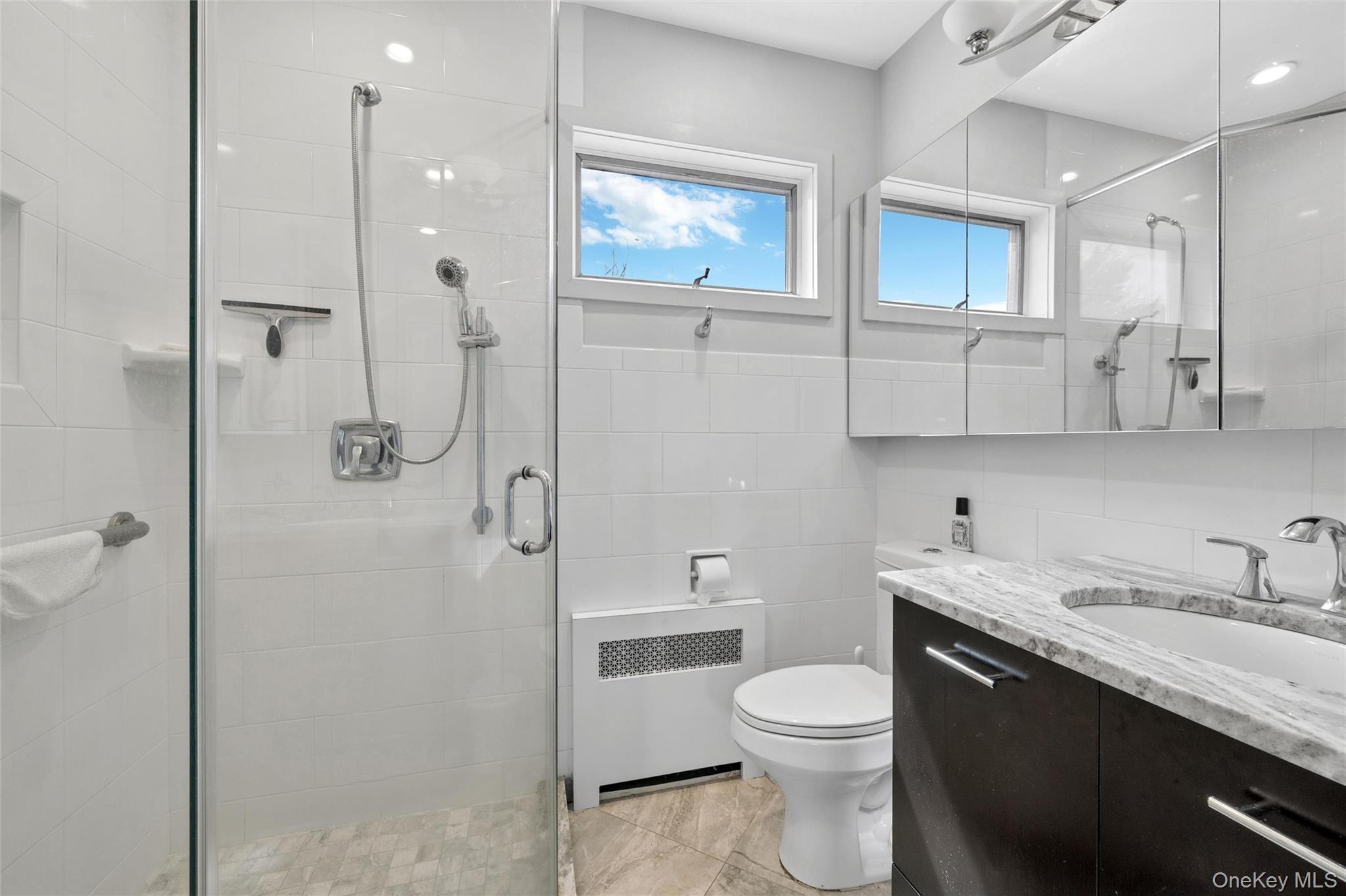 24 Allen Road Rockville Centre, NY 11570 - Photo 26 of 46 a bathroom with a granite countertop sink a toilet and shower