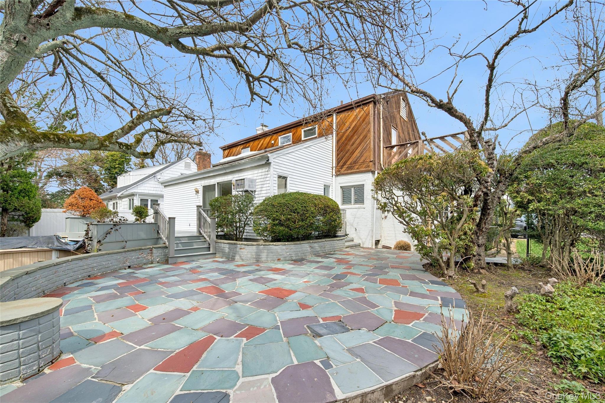 24 Allen Road Rockville Centre, NY 11570 - Photo 36 of 46 a backyard of a house with large trees and outdoor seating