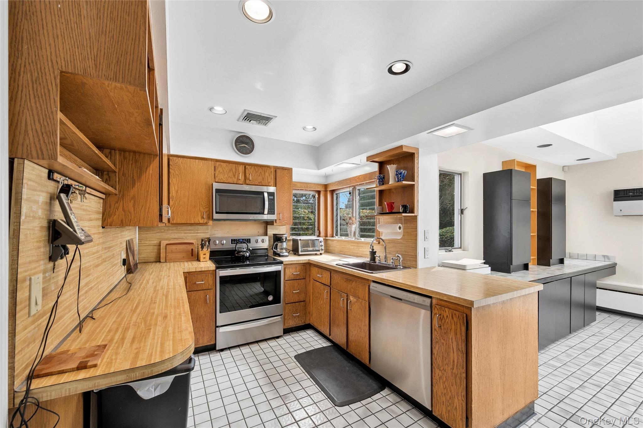 24 Allen Road Rockville Centre, NY 11570 - Photo 10 of 46 a kitchen with stainless steel appliances kitchen island granite countertop a sink and cabinets