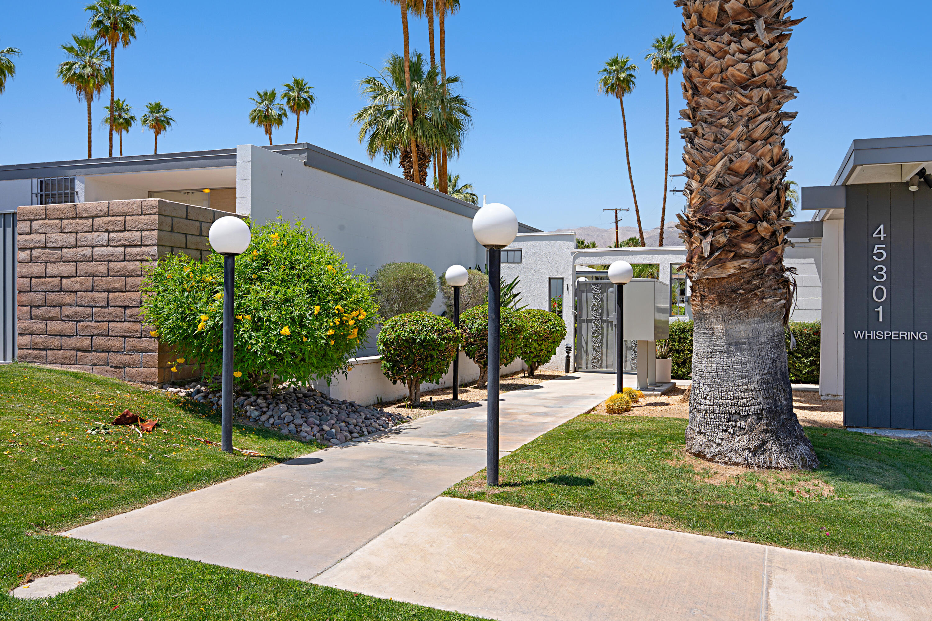45301 Deep Canyon Road, Unit 21 Palm Desert, CA 92260 - Photo 2 of 46 a view of a house with a backyard and garden