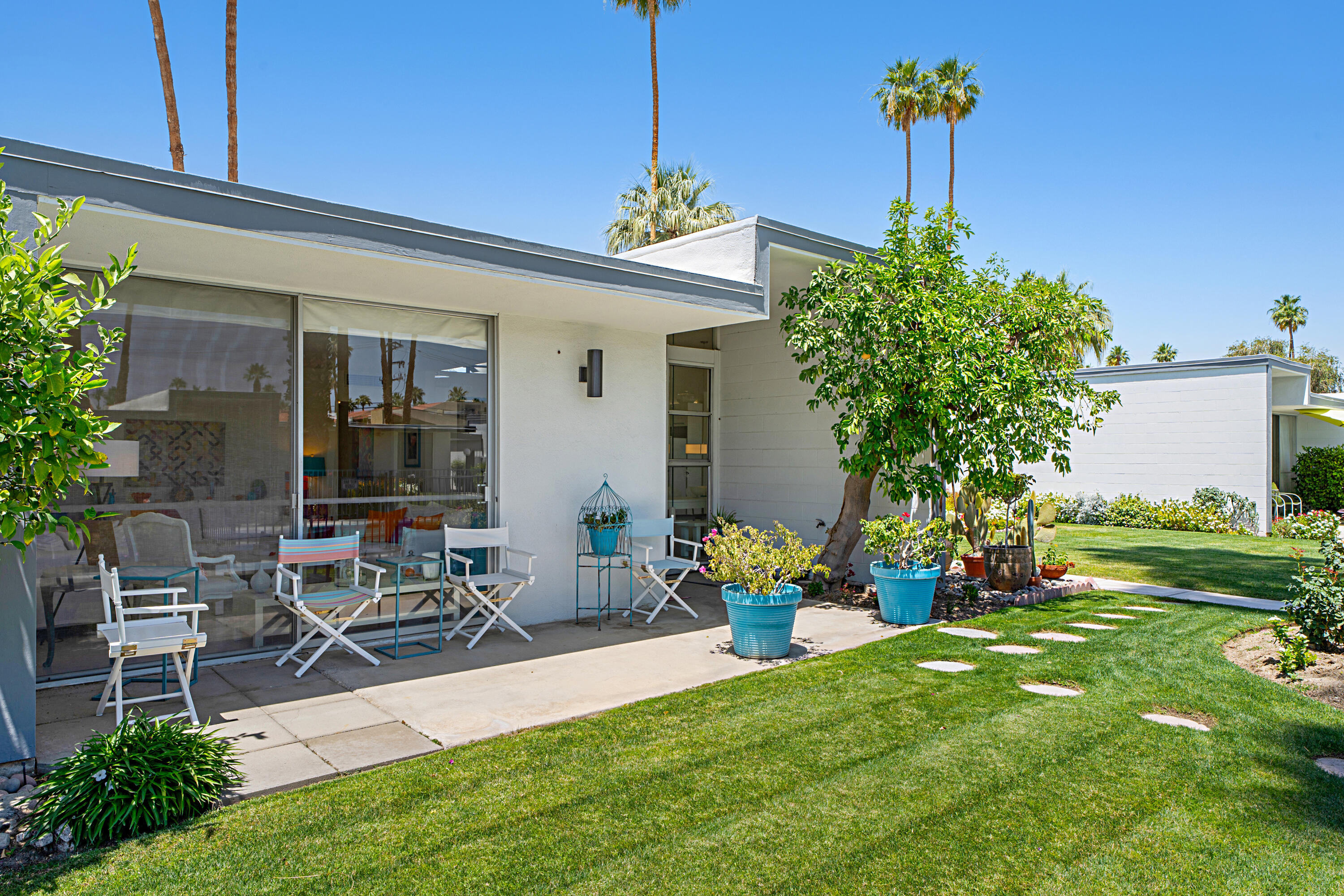 45301 Deep Canyon Road, Unit 21 Palm Desert, CA 92260 - Photo 4 of 46 a front view of a house with garden and sitting area