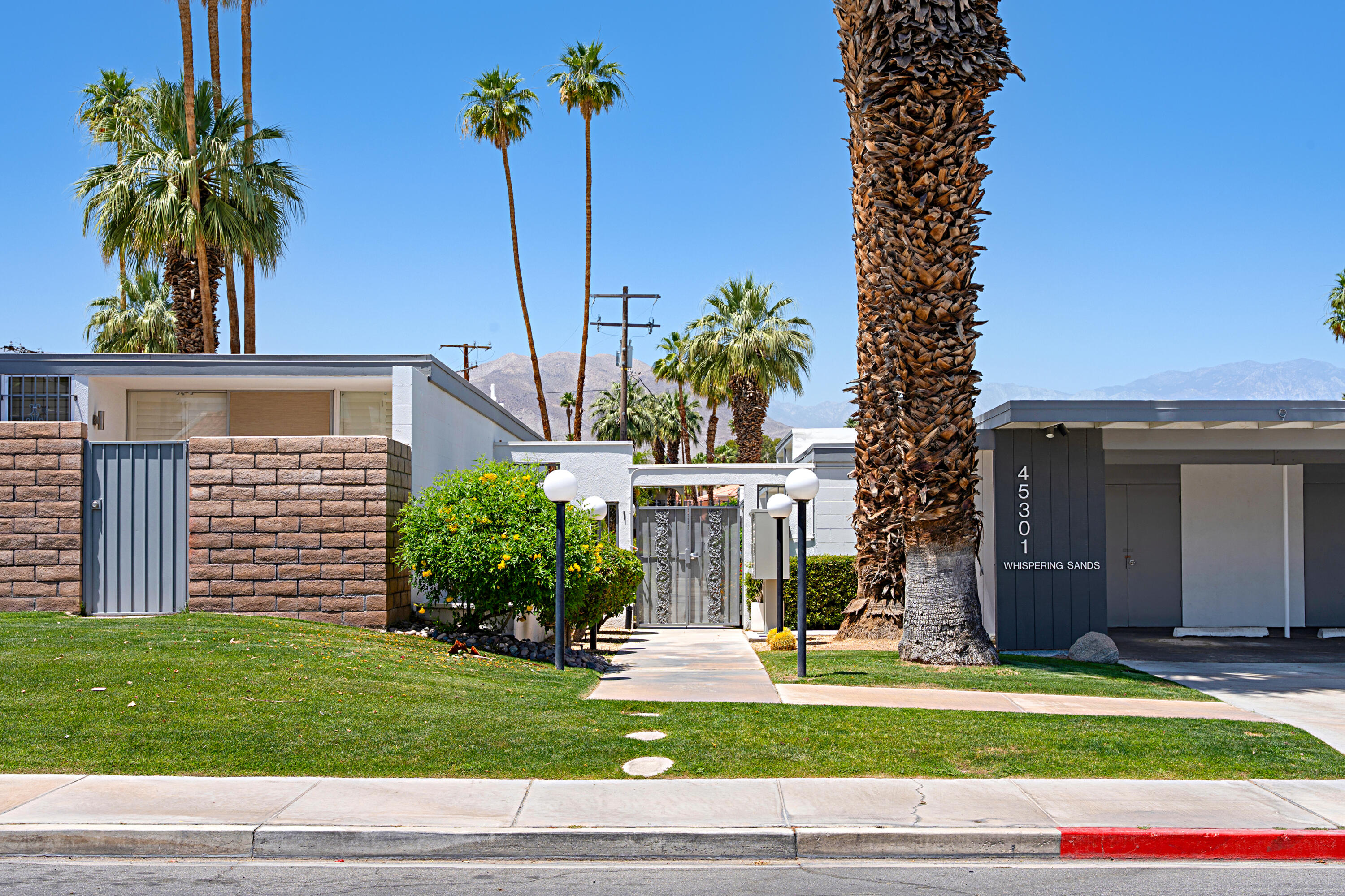 45301 Deep Canyon Road, Unit 21 Palm Desert, CA 92260 - Photo 41 of 46 a view of a house with a yard and potted plants