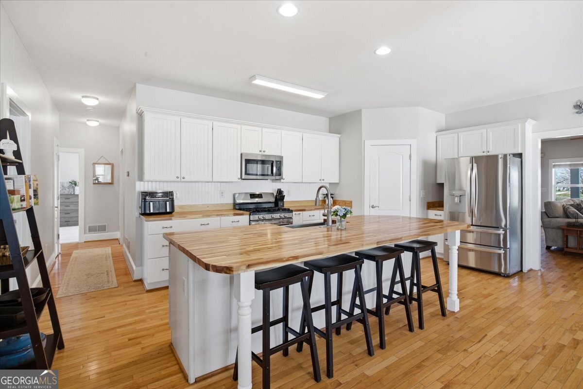 204 Staples Dairy Road Carrollton, GA 30116 - Photo 14 of 85 a kitchen with stainless steel appliances granite countertop a table chairs sink refrigerator and microwave