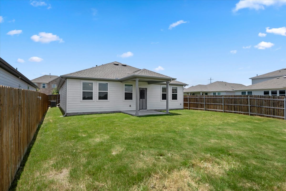 500 Stinchcomb Road Hutto, TX 78634 - Photo 8 of 37 A generous lawn and sheltered patio create an ideal setting for outdoor activities.