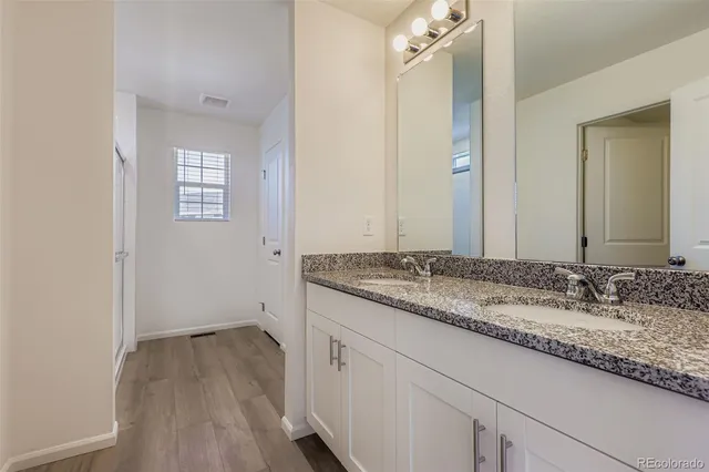 a bathroom with a granite countertop sink and a mirror