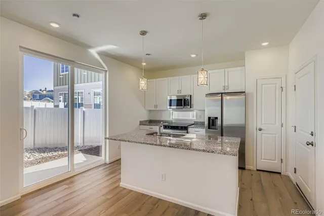 a kitchen with stainless steel appliances granite countertop a refrigerator and a stove top oven