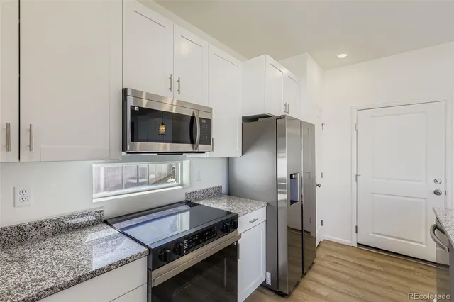 a kitchen with stainless steel appliances granite countertop a refrigerator and a stove top oven
